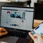 Marketer managing paid ad campaigns across laptop and smartphone