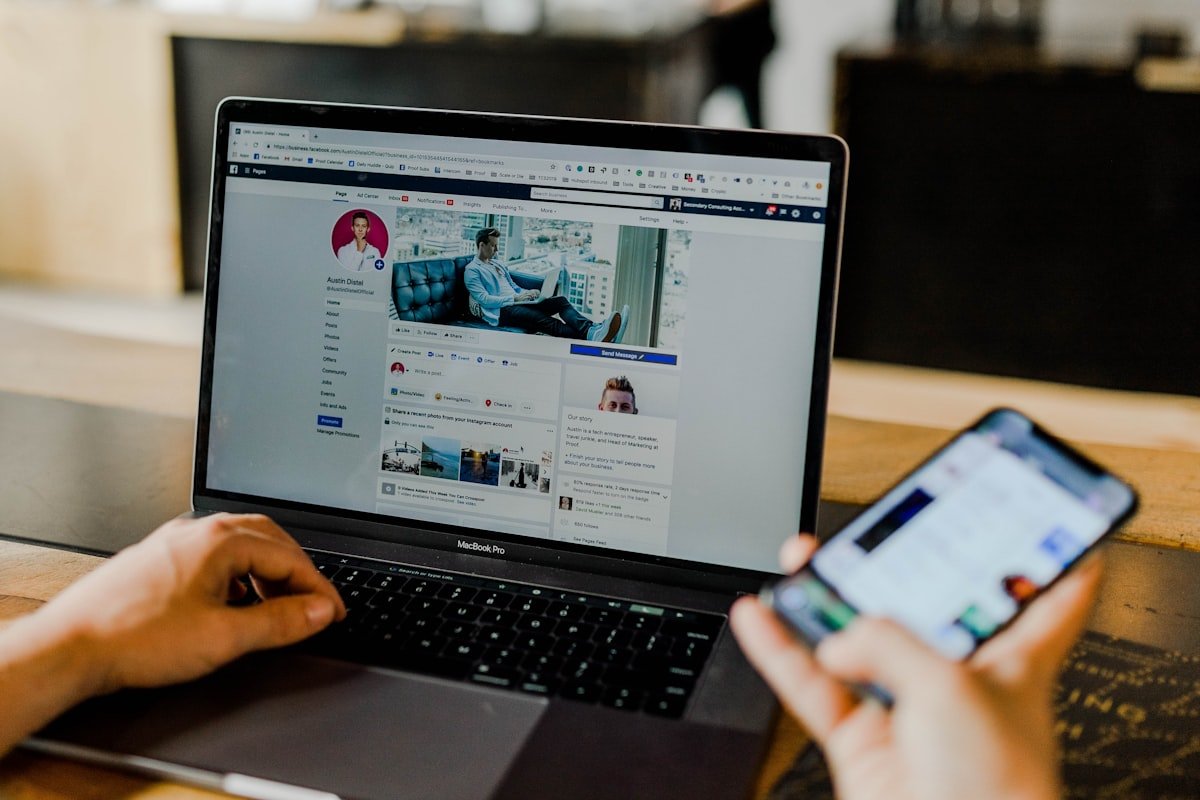 Marketer managing paid ad campaigns across laptop and smartphone